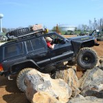 A Jeep Cherokee climbs over rock obstacles