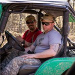 A wounded vet sits shotgun in the Frag Our Armor green Jeep