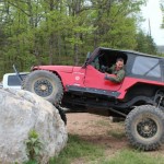 Wounded Veteran John Patterson drive a Jeep Wrangler over a large rock