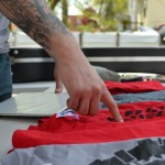 A volunteer points to a red 4W2H "Tread Lightly" T-shirt