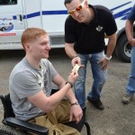 JP gives a wrist band to a wounded veteran